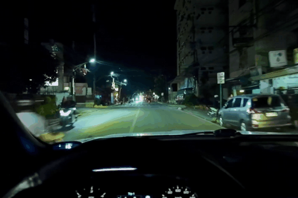 A nighttime view from inside a car with nano-ceramic tinted windows, showing a clear and glare-free street scene. The tint combines exceptional clarity with advanced heat rejection and durability for a premium driving experience.